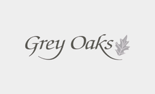 Grey Oaks logo in cursive with a leaf motif.